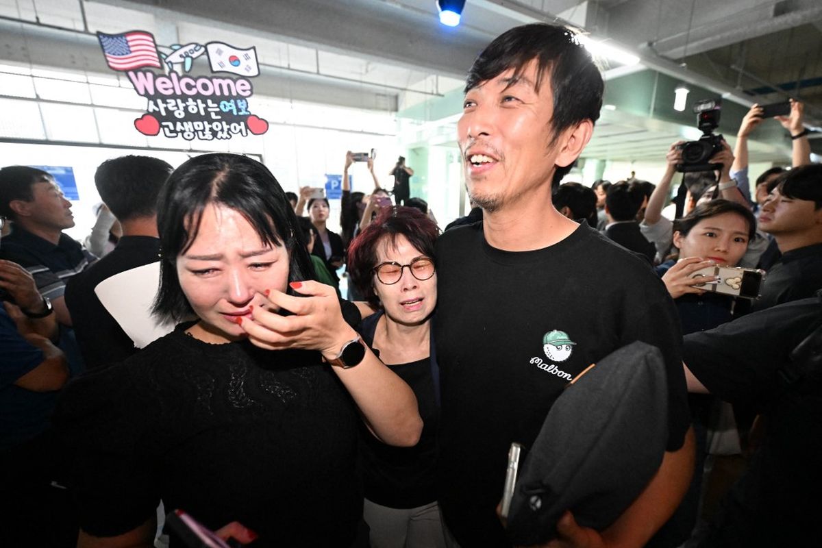 Seorang pekerja Korea Selatan (kanan), yang ditahan dalam penggerebekan imigrasi AS di pabrik Hyundai-LG di Ellabell, Georgia, disambut oleh keluarganya setelah kembali dari Atlanta di tempat parkir Bandara Internasional Incheon, Incheon, pada 12 September 2025. 