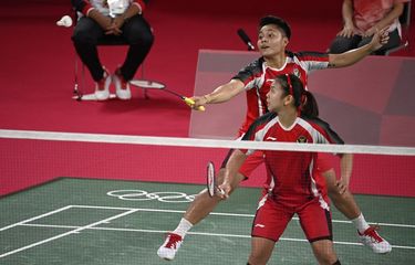 Atlet Indonesia Apriyani Rahayu (belakang) melakukan pukulan dalam pertandingan penyisihan grup bulu tangkis ganda putri bersama pasangannya, Greysia Polii (depan), melawan Lee Meng Yean dan Chow Mei Kuan dari Malaysia pada Olimpiade Tokyo 2020 di Musashino Forest Sports Plaza di Tokyo pada 24 Juli 2021.