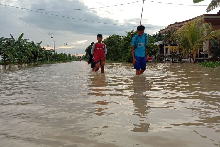 Anak - anak menerobos genangan banjir di Desa Trimulyo Kecamatan Guntur Kabupaten Demak, Jateng, mereka tidak masuk sekolah karena sekolahnya terendam air, Jumat (10/1/2020) pagi