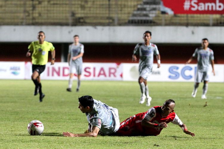 Pemain Persija Jakarta Riko Simanjuntak (kanan) terjatuh seusai duel udara dengan pemain Persib Bandungs saat final Piala Menpora 2021 leg pertama yang berakhir dengan skor 2-0 di Stadion Maguwoharjo Sleman, Kamis (22/04/2021) malam. 