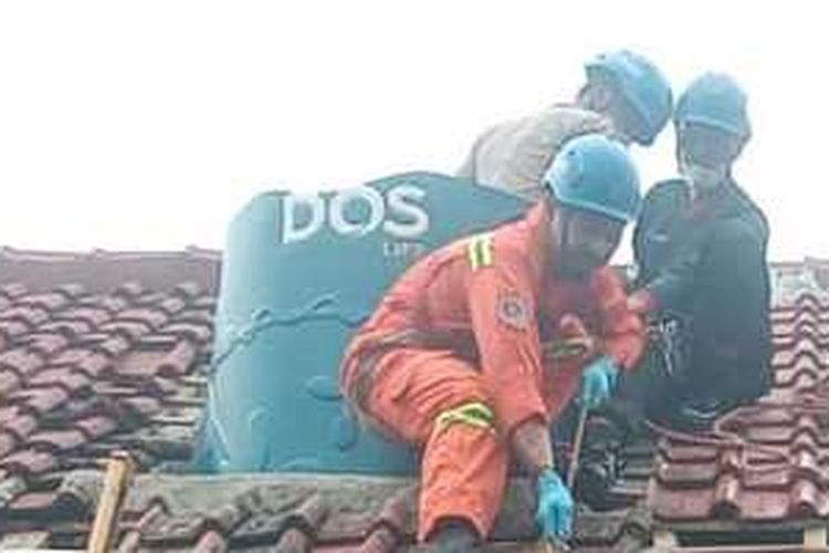 Petugas Kepolisian Polsek Singaparna, BPBD, Inafis dan TNI sedang mengevakuasi mayat korban yang tenggelam di dalam toren sebuah bangunan kontrakan di Singaparna, Kabupaten Tasikmalaya, Jawa Barat, Selasa (28/10/2025).