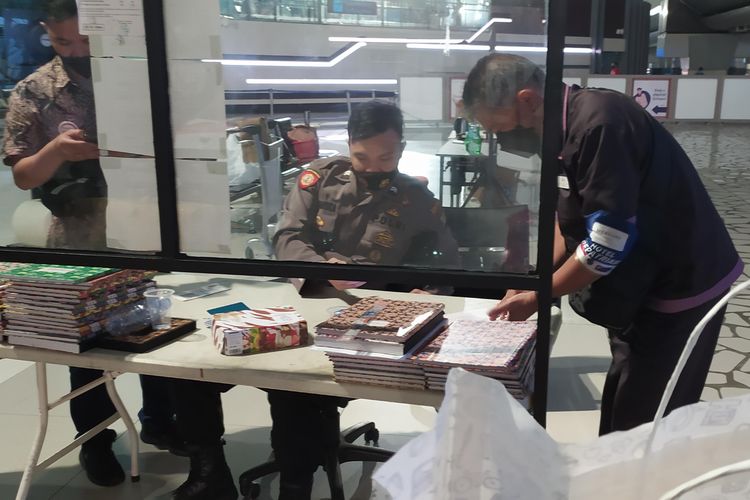 Petugas kepolisian di pintu keluar Bandara Internasional Soekarno-Hatta memeriksa hasil negatif tes PCR yang dilakukan saat penumpang mendarat, Sabtu (30/10/2021). Hasil negatif tes PCR sebagai syarat bagi penumpang keluar bandara dan melanjutkan kewajiban karantina lima hari. Hasil PCR didapat dalam waktu 2-5 jam.
