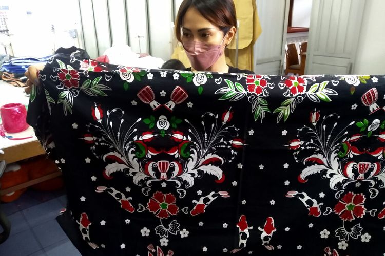 Santika menunjukkan batik buatan Batik Mawar Putih dengan motif ikan koi yang merupakan salah satu produk unggulan Blitar, Selasa (8/2/2022)