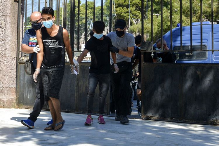 Four Afghan migrants have been charged with arson for their alleged involvement in the Lesbos fire that destroyed a large part of the refugee camp.