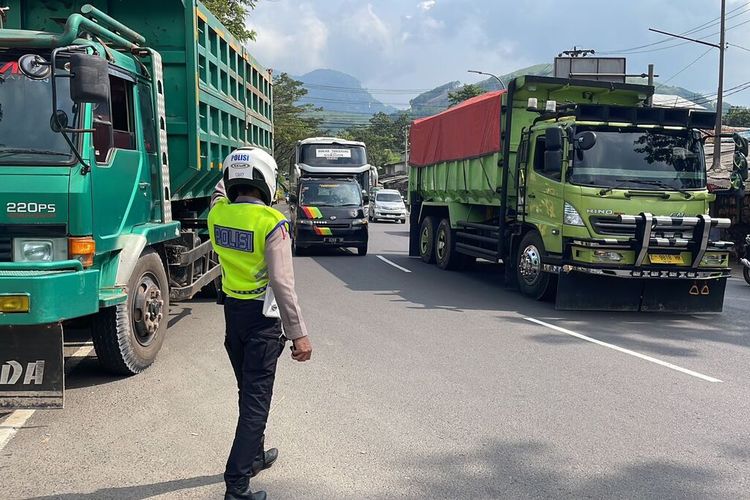 Sejumlah petugas daro jajaran Polresta Bandung saat tengah mengatur arus lalu lintas di kawasan Jalan Cagak, Nagreg, Kabupaten Bandung, Jawa Barat pada Minggu (30/4/2023).