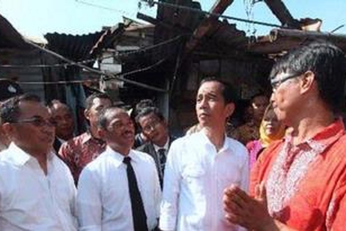 Gubernur DKI Jakarta, Joko Widodo bersama Walikota dan Wakil Walikota Jakarta Timur, H.R. Krisdianto (kedua dari kiri) dan Husein Murad (kiri) mendengarkan penjelasan dari sekretaris RW 05, Asit Faisal, saat berkeliling kampung usai pelantikan wali kota dan wakil walikota di lapangan sepak bola Kampung Pulo Jahe, RT 07 RW 5 Kelurahan Jatinegara, Cakung, Jakarta Timur, Kamis (20/12/2012). Selain untuk mengingatkan bahwa pejabat harus melayani masyarakat, pelantikan yang dilakukan di kampung kumuh itu juga agar pejabat terkait mengetahui permasalahan yang dihadapi warga. Kompas/Wisnu Widiantoro
