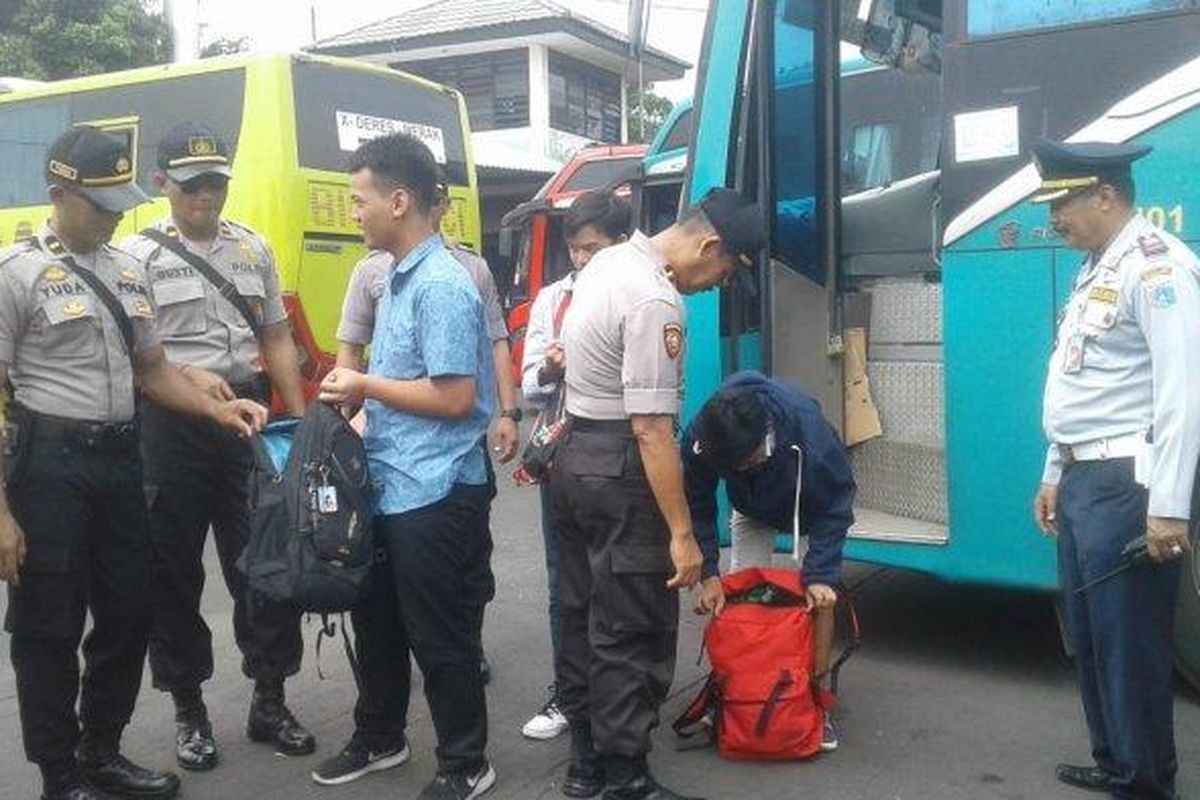 Petugas gabungan memeriksa barang bawaan penumpang bus luar kota yang tiba di Terminal Kalideres, Jakarta Barat. 