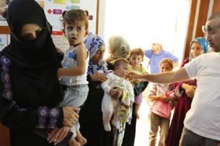 Para pengungsi Suriah antri untuk mendapatkan perawatan medis. ISIS diduga merekrut para dokter untuk memperkuat pasukan pejuang asing.