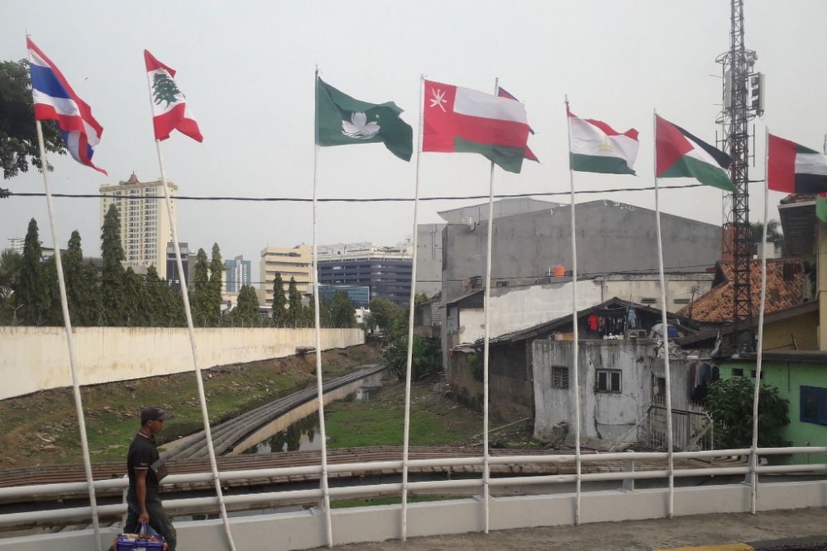 Deretan bendera negara peserta Asian Games yang dikibarkan menggunakan batang bambu di kawasan Kali Besar, Jakarta Barat, Selasa (17/7/2018).