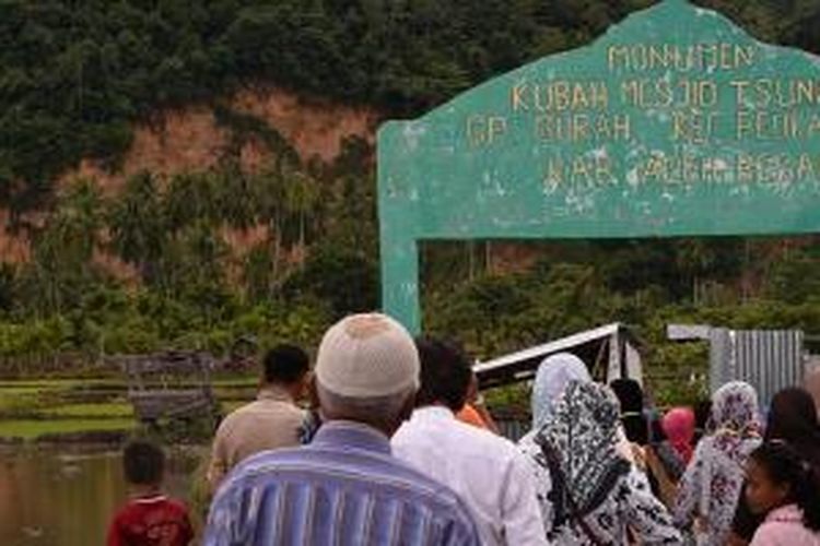 Wisatawan dari perkumpulan pengajian Masjid Tengku Ampuan Jamaah, Syah Alam, Selangor, Malaysia mengunjungi situs tsunami kubah masjid yang hanyut di Desa Gurah, Kecamatan Peukan Bada, Aceh Besar, Minggu (26/10/2014). Saat musibah tsunami melanda Aceh 26 Desember 2004 lalu, kubah masjid tersebut terseret arus sekitar 2,5 kilometer dari posisi sebelumnya di Desa Lam Teungoh, Aceh Besar. 