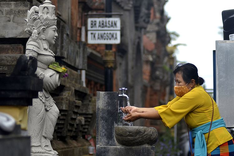 Umat Hindu mencuci tangan saat akan bersembahyang Hari Raya Galungan di Pura Jagatnatha, Denpasar, Bali, Rabu (16/9/2020). Perayaan Hari Raya Galungan yang merupakan hari kemenangan kebenaran (Dharma) atas kejahatan (Adharma) tersebut diikuti umat Hindu di Pulau Dewata dengan tetap menerapkan protokol kesehatan secara ketat untuk mencegah penyebaran pandemi COVID-19.