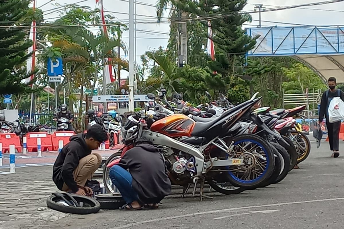 Dua orang yang motornya terjaring razia polisi dikenakan sanksi mengganti knalpot dan ban motor yang sesuai standar didepan Satlantas Purworejo pada Senin (29/8/2022). 