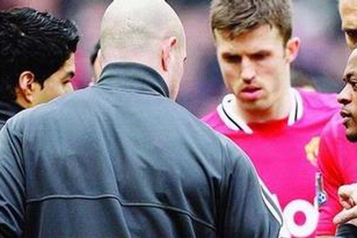 Bek Manchester United, Patrice Evra (kanan), berupaya menjabat tangan striker Liverpool, Luis Suarez (kiri), pada laga Liga Primer di Stadion Old Trafford, Manchester, Inggris, Sabtu (11/2). Suarez menolak bersalaman dengan Evra dalam pertandingan pertama setelah sanksi larangan delapan kali bertanding karena bertindak rasialis terhadap Evra, Oktober 2011.