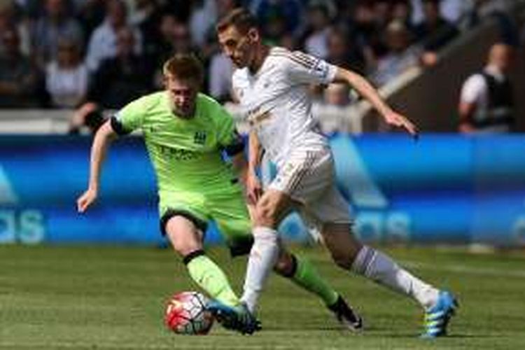 Gelandang Manchester City, Kevin de Bruyne (kiri), berduel dengan bek Swansea City, Angel Rangel, dalam laga pekan ke-38 Premier League di Stadion Liberty, Minggu (15/5/2016).