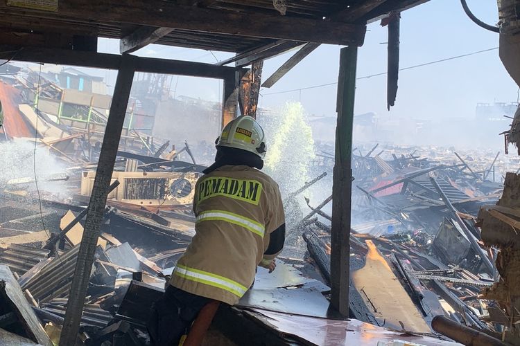 Sejumlah personel pemadam kebakaran melakukan upaya pendinginan di lokasi kejadian di Kampung Nelayan Muara Angke RT 012 RW 022 Tembok Bolong, Penjaringan, Jakarta Utara, Sabtu (22/4/2023).