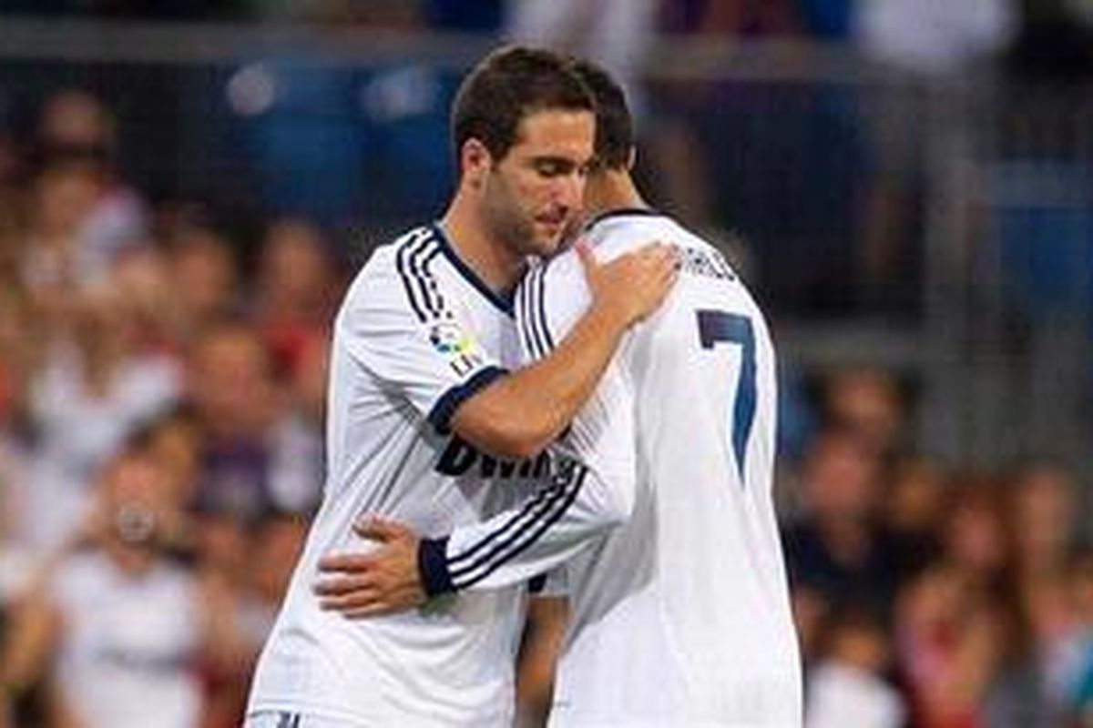 Bomber Real Madrid dari Portugal, Cristiano Ronaldo (kanan), keluar lapangan dan digantikan rekan seklubnya dari Argentina, Gonzalo Higuain, saat melawan Granada dalam lanjutan Liga BBVA di Stadionm Santiago Bernabeu, Minggu (2/9/2012). Madrid menang 3-0 dan Ronaldo memborong dua gol di antaranya. 
