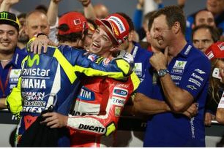 Dua pebalap Italia, Andrea Iannone (Ducati) dan Valentino Rossi (Movistar Yamaha), seling memberikan selamat setelah menyelesaikan GP Qatar di Sirkuit Losail, Minggu (29/3/2015).