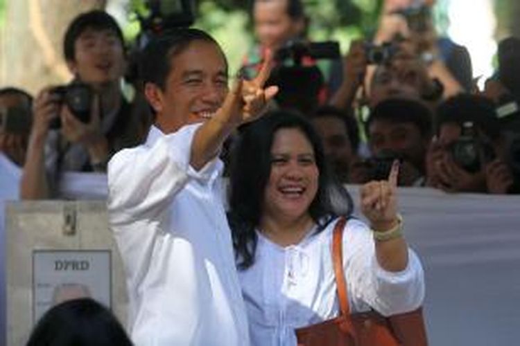 Gubernur DKI Jakarta Joko Widodo atau Jokowi (kiri) bersama istrinya, Iriana, menunjukkan jari mereka yang telah tercelup tinta usai mencoblos di tempat pemungutan suara (TPS) 27, Taman Suropati, Menteng, Jakarta Pusat, dalam Pemilu Legislatif 2014, Rabu (9/4/2014).