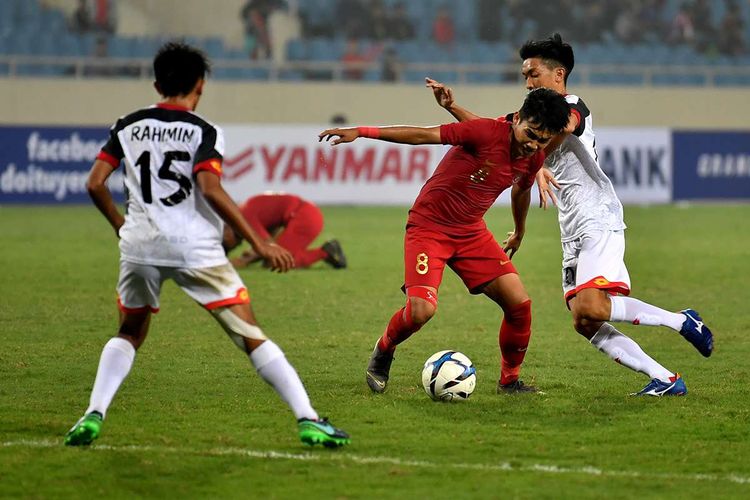 Pesepak bola tim nasional Indonesia U-23 Witan Sulaeman (tengah) berupaya melepaskan diri dari kawalan dua pesepak bola tim nasional Brunei Darussalam U-23 Azim Izamuddin (kanan) dan Rahmin Abdul Ghani (kiri) pada pertandingan sepak bola Grup K kualifikasi Piala Asia U-23 AFC 2020 di Stadion Nasional My Dinh, Hanoi, Vietnam, Selasa (26/3/2019). Tim nasional Indonesia U-23 mengalahkan tim nasional Brunei Darussalam U-23 dengan skor 2-1.
