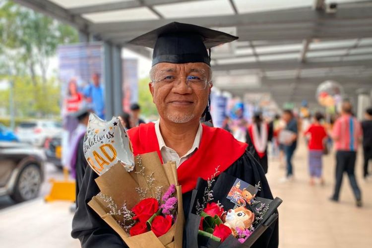 Abah Aiman berpose mengenakan pakaian wisuda beserta pernak-pernik lainnya di hari kelulusan sang putra dari perguruan tinggi.