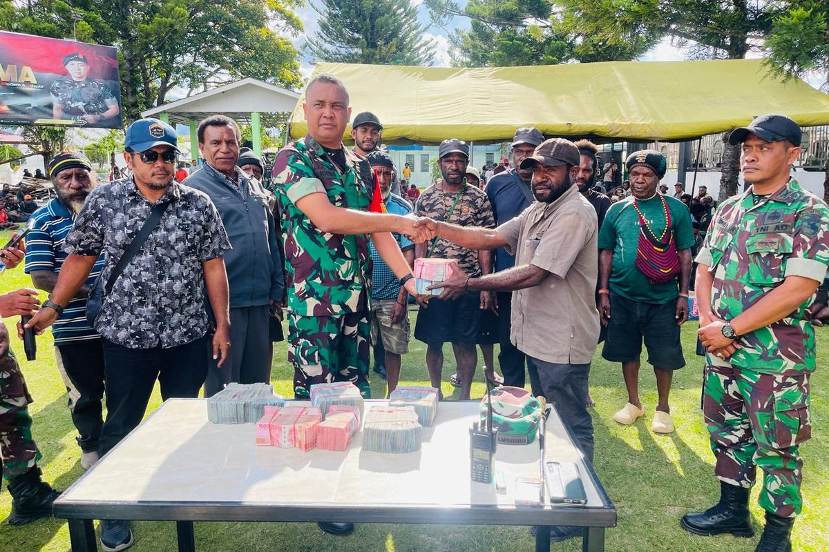 Komandan Komando Distrik Militer (Dandim) 1702 Jayawijaya, Letkol Arh. Reza Mamoribo saat menyerahkan uang denda adat kepada keluarga korban. 