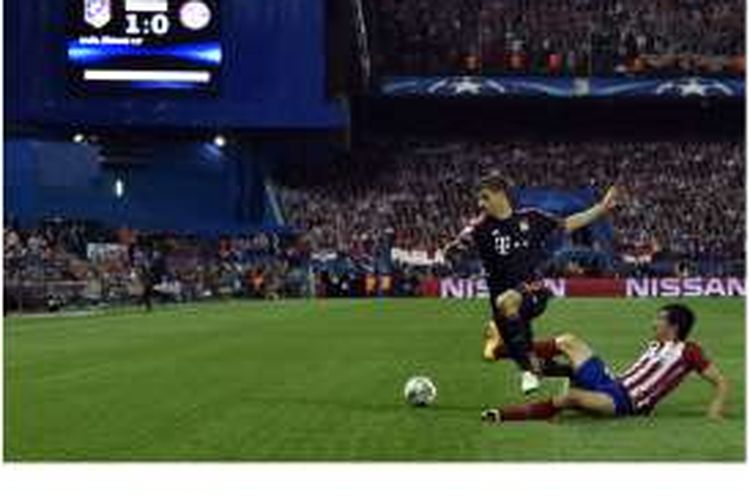 Gelandang Bayern Muenchen, Thomas Mueller (kiri), ditekel oleh bek Atletico Madrid asal Montenegro, Stefan Savic, pada pertandingan leg pertama semifinal Liga Champions di Stadion Vicente Calderon, Rabu (27/4/2016).