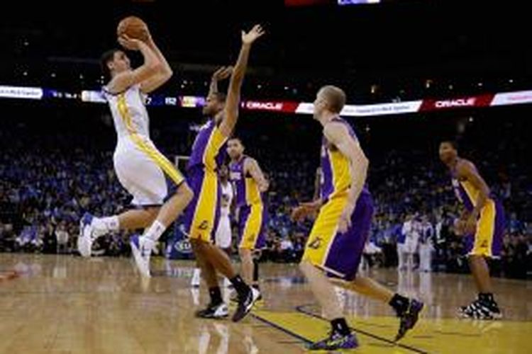 Pebasket Golden State Warriors,  Klay Thompson (11) melakukan tembakan di depan para pemain Los Angeles Lakers, pada laga lanjutan NBA musim ini di Oracle Arena, Oakland, California, Rabu (30/10/2013).
