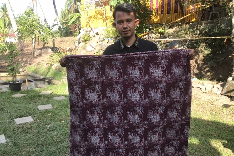 Pemilik usaha batik khas Minang bermerek Salingka Tabek, Yusrizal (29) saat ditemui di rumahnya di Sawah Parik, Desa Bawah Duku, Kecamatan Kotobaru, Solok, Sumatera Barat pada Rabu (18/5/2022). Ia memegang kain batik bermotifkan rumah gadang.