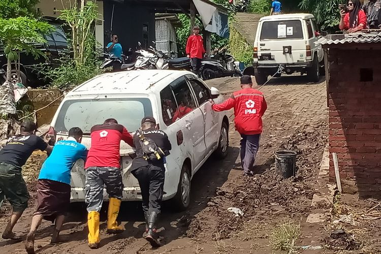 Warga di RT 05 RW 08, Kelurahan Pandanwangi, Kecamatan Blimbing, Kota Malang, Jawa Timur bersama tim relawan bergotong royong membersihkan material lumpur akibat banjir yang terjadi pada Senin (14/3/2022).