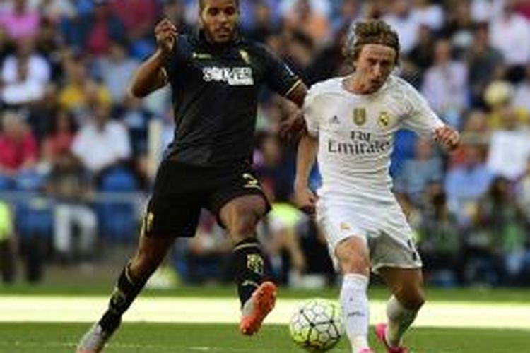 Gelandang Real Madrid Luka Modric (kanan) berduel dengan penyerang Granada asal Maroko, Youssef El-Arabi, dalam pertandingan La Liga di Santiago Bernabeu, Sabtu (19/9/2015).