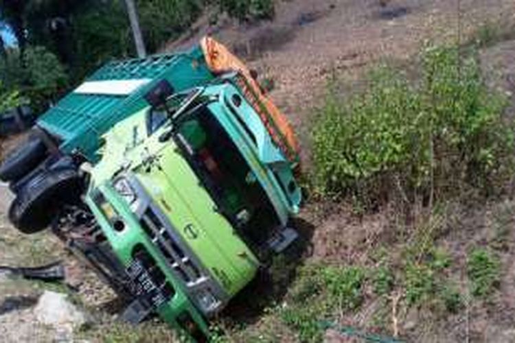 Kondisi truk Hino yang terpental dan terguling di pinggir jalan Trans Sulawesi setelah baku hantam dengan Avanza. Kedua sopir selamat dalam kecelakaan ini
