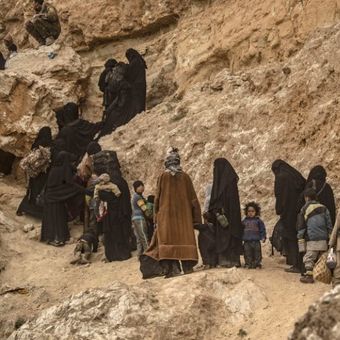 Anggota ISIS berserta istri dan anak-anak mereka keluar dari desa Baghouz di provinsi Deir Ezzor, Suriah timur, Kamis (14/3/2019). (AFP/Delil Souleiman)