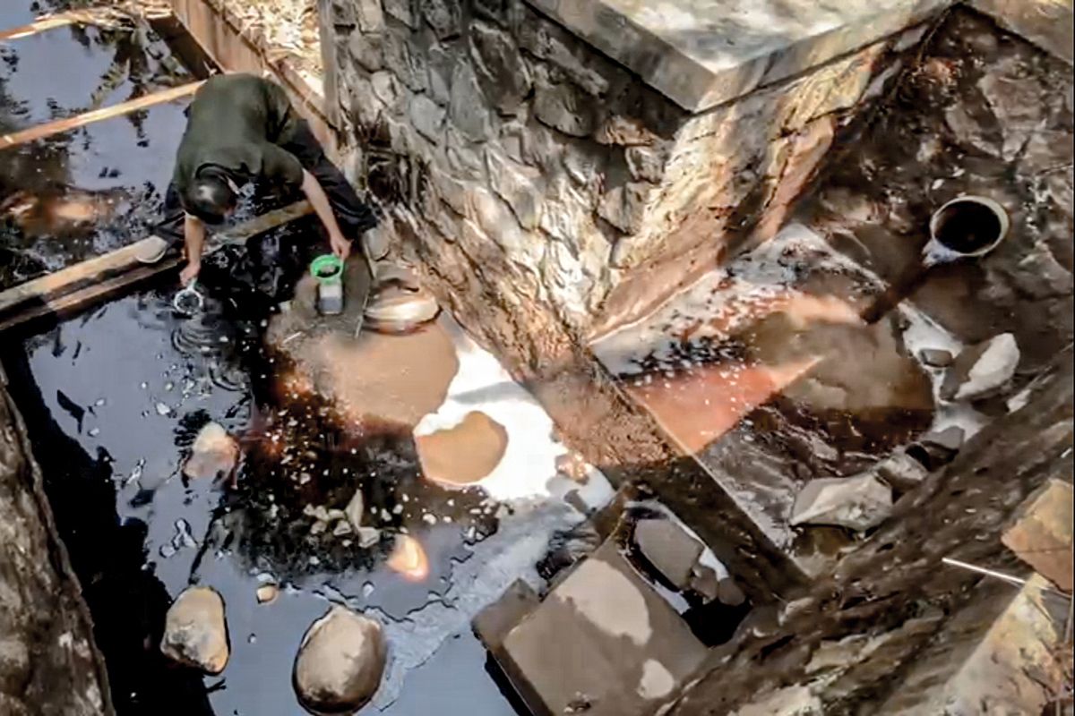 Aktivis lingkungan yang tergabung dalam Tim Masyarakat Peduli TPA Sarimukti melakukan pengambilan sampel air lindi di outfall IPAL TPA Sarimukti, Minggu (30/7/2023).