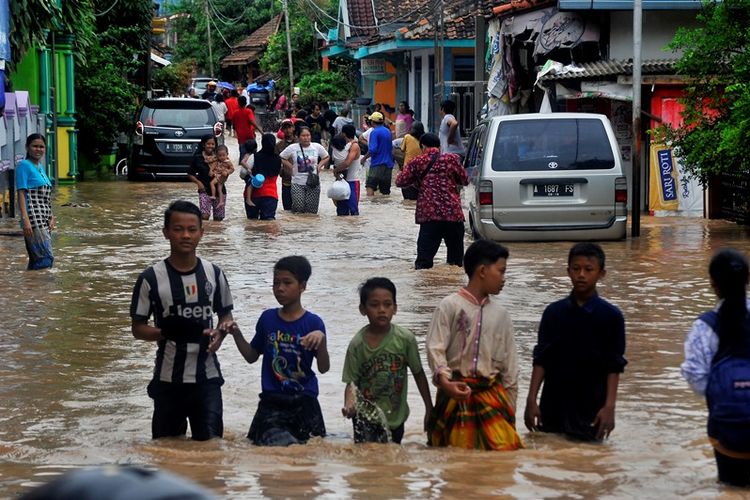 Sejumlah warga keluar rumah menuju tempat pengungsian setelah kampung mereka terendam banjir di Kampung Cibeber, Cilegon, Banten, Rabu (25/4). Banjir terjadi akibat penggundulan hutan secara masif di Bukit Panenjoan hingga Gunung Pinang sehingga air meluap setelah terjadi hujan deras selama dua hari di daerah itu. 