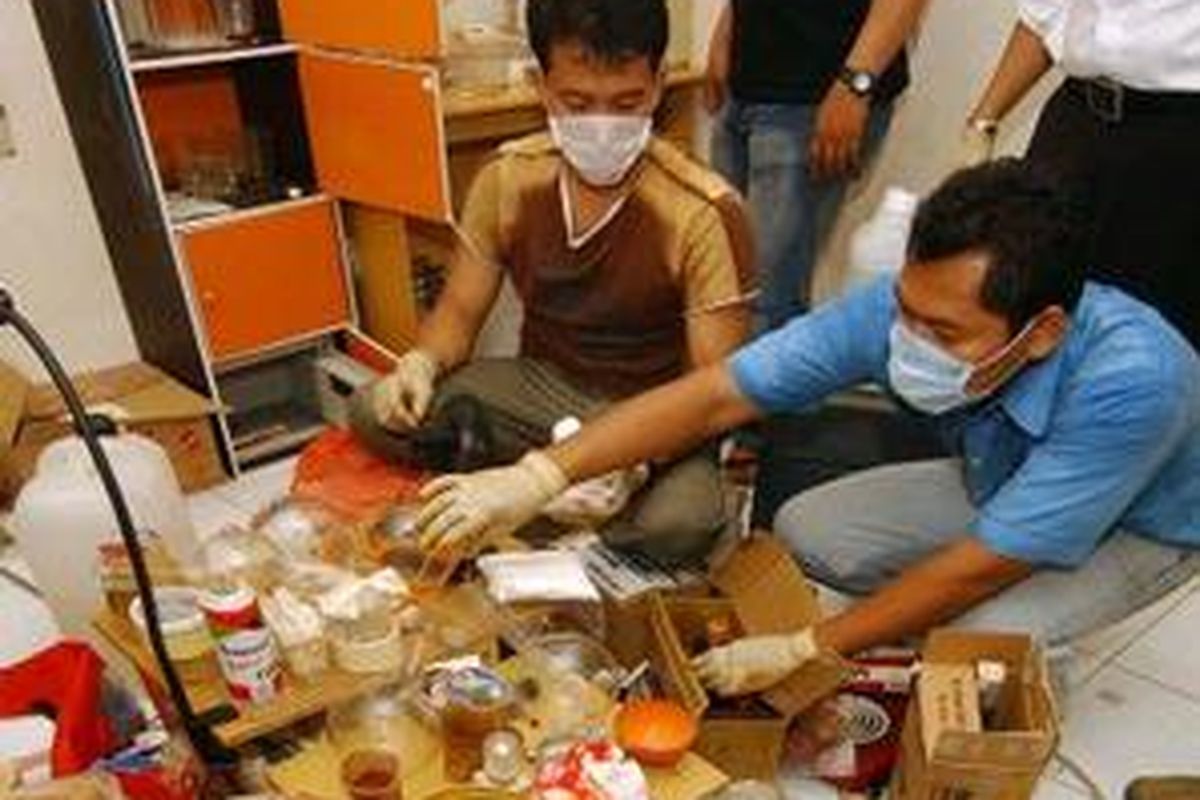 Petugas Sat Narkoba Idik II Polwiltabes Surabaya memeriksa peralatan dan bahan baku di sebuah home industri sabu-sabu yang berada di kawasan Jemursari Timur Blok JI Surabaya, Jumat (12/9).