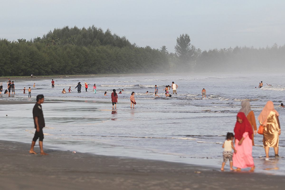 Pengunjung menikmati liburan di kawasan objek wisata Pantai Desa Suak Timah, Kecamatan Samatiga, Aceh Barat, Aceh, Selasa (26/5/2020). Meskipun dalam masa pandemi Covid-19, warga tetap ramai mengunjungi objek wisata pantai untuk menghabiskan waktu libur Idul Fitri 1441 Hijriah tanpa memperhatikan protokol kesehatan seperti menjaga jarak dan memakai masker.