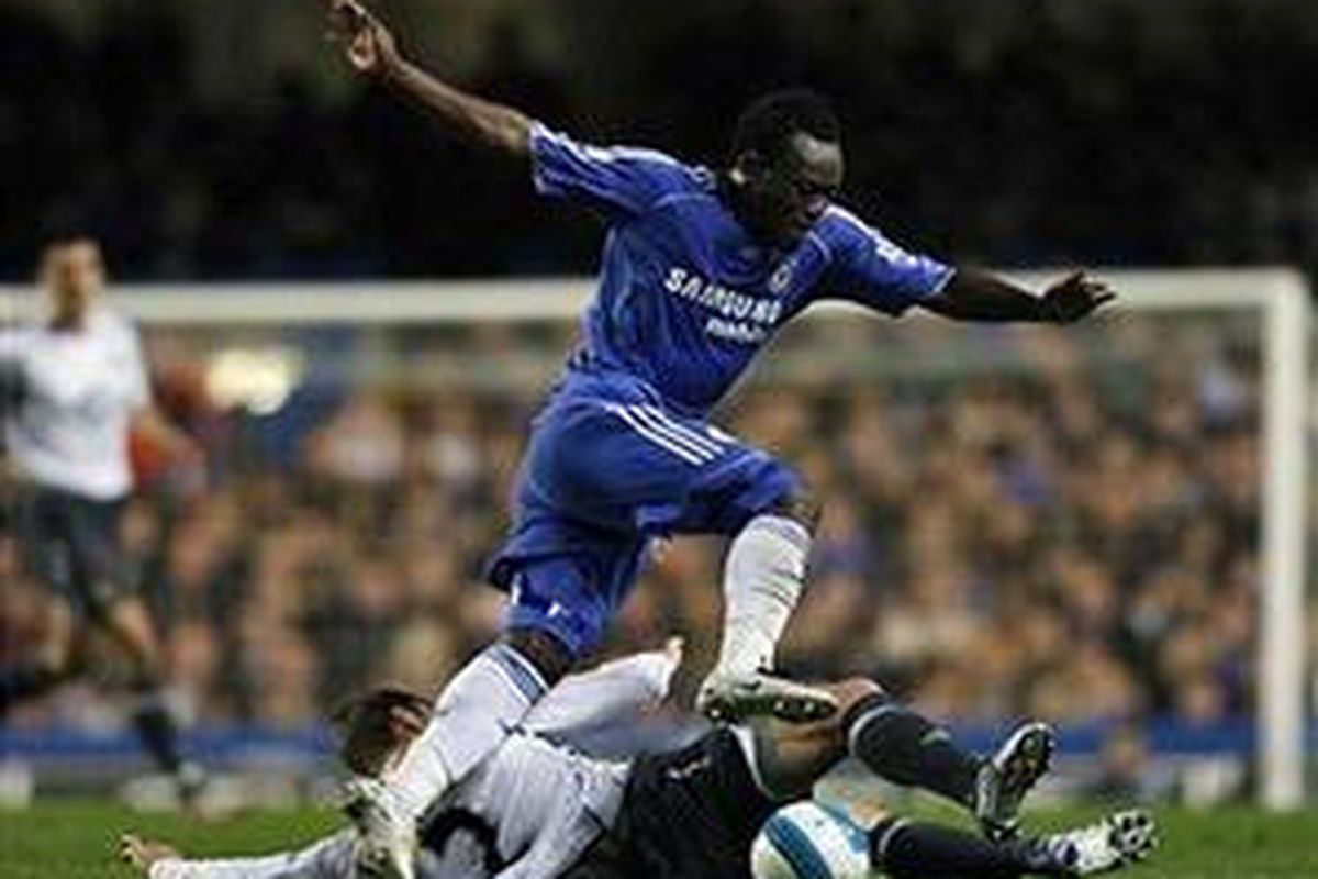 Gelandang Chelsea, Michael Essien, ditakel pemain Wigan, Ryan Taylor. Dia akhirnya mencetak gol, tapi gagal membawa kemenangan timnya.