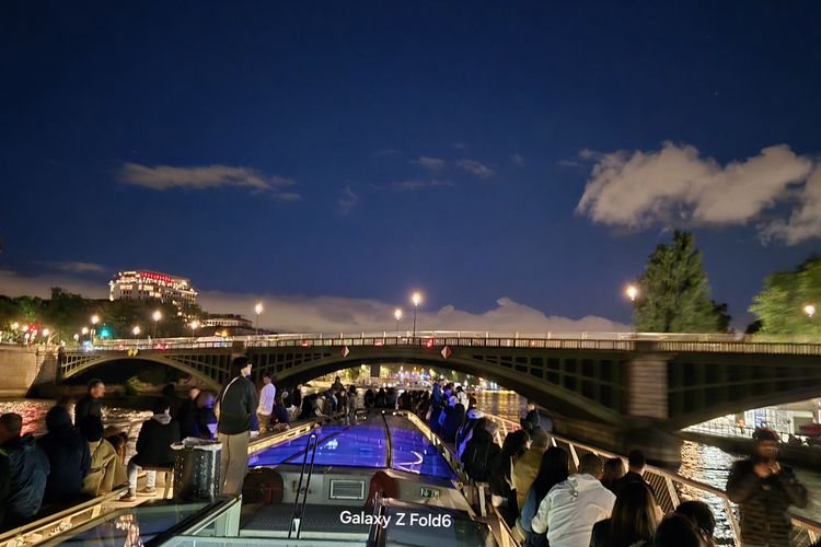 Pemandangan langit malam dan kota Paris dari atas kapal yang melaju di sepanjang Sungai Seine.