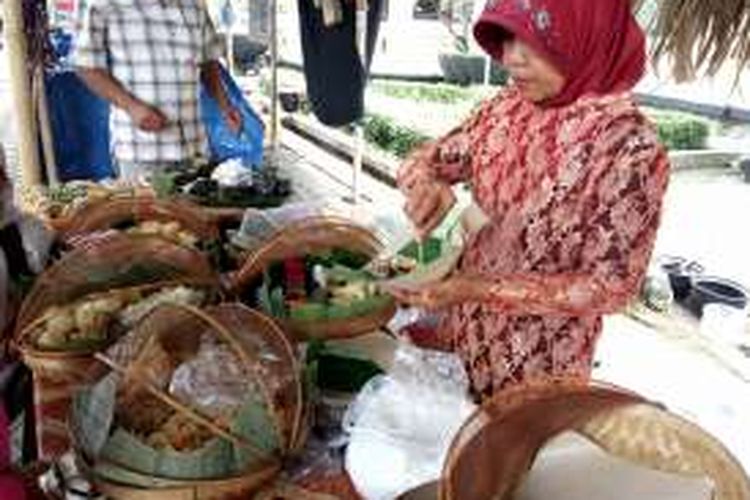 Ibu Bagyo saat melayani pembeli makanan tempo dulu di Pasar Kangen Jogja, Kamis (21/7/2016).