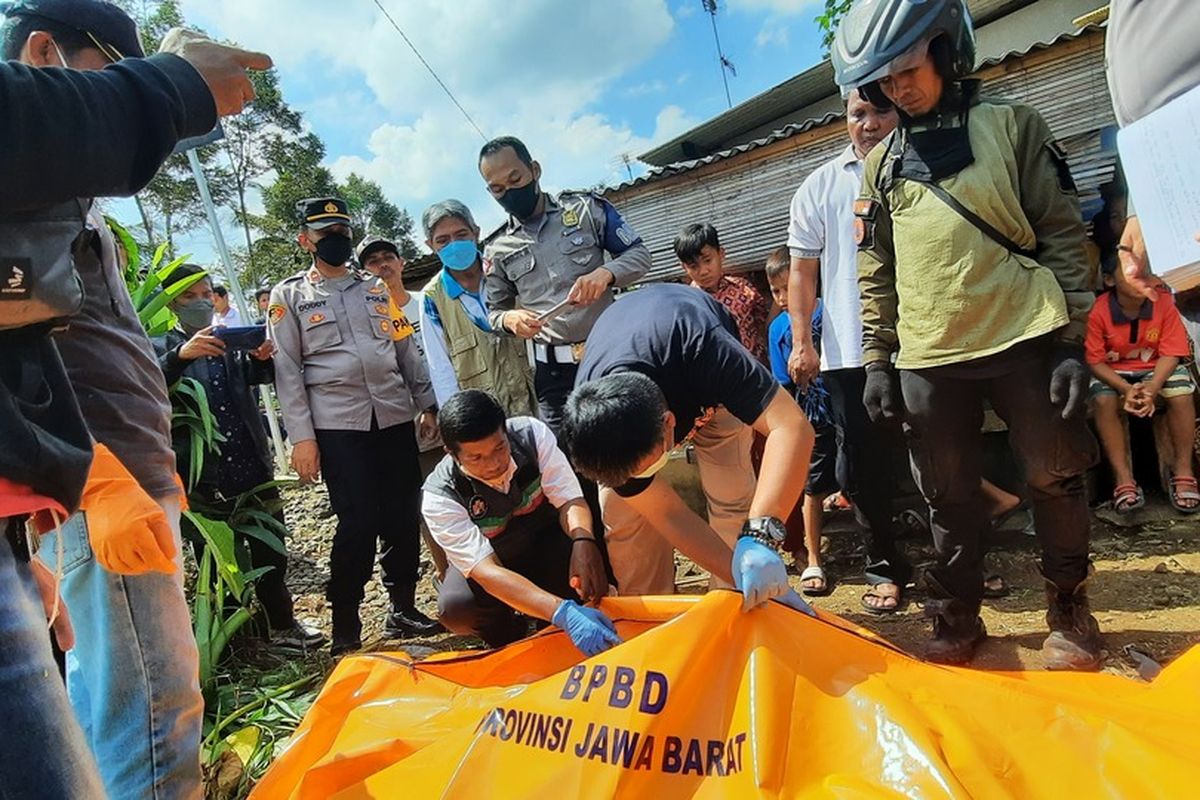 Petugas Unit Inafis Polresta Tasikmalaya sedang memeriksa jenazah korban tertabrak kereta api Lodaya arah Tasikmalaya-Solo di perlintasan rel tanpa palang pintu di dekat Pontren Miftahul Huda Manonjaya, Kabupaten Tasikmalaya, Jawa Barat, Rabu (8/6/2022) siang.