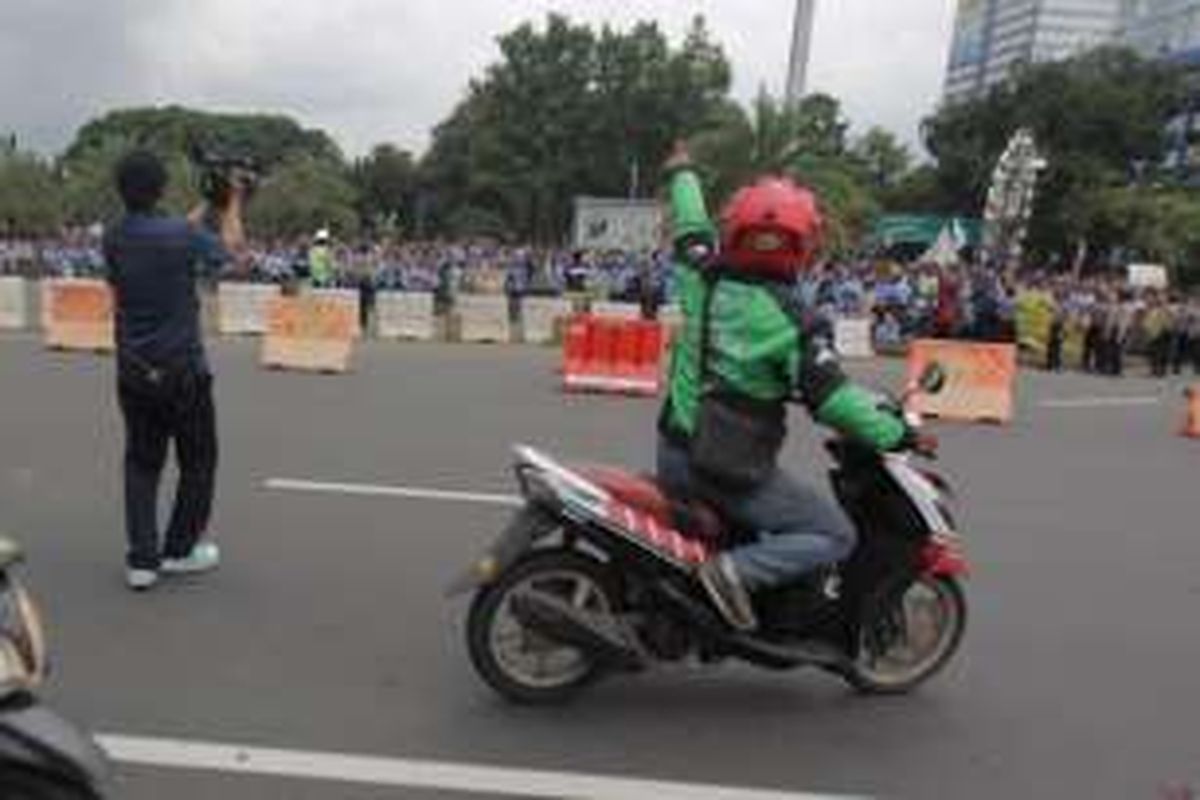 Pengemudi ojek online memprovokasi para sopir taksi yang melakukan aksi demonstrasi di kawasan monas, Jakarta, Selasa (22/3/2016). Para ojek online ini kesal akibat salah satu temannya disweeping dan dipukuli. KOMPAS.com / RODERICK ADRIAN MOZES