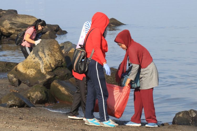 Aparatur Sipil Negara (ASN) dan Tenaga Harian Lepas (THL) dari berbagai Satuan Kerja Perangkat Daerah (SKPD) Kota Manado bergotong royong membersihkan sampah yang ada di sekitar Pantai Megamas, Menado, Jumat (20/10/2018).