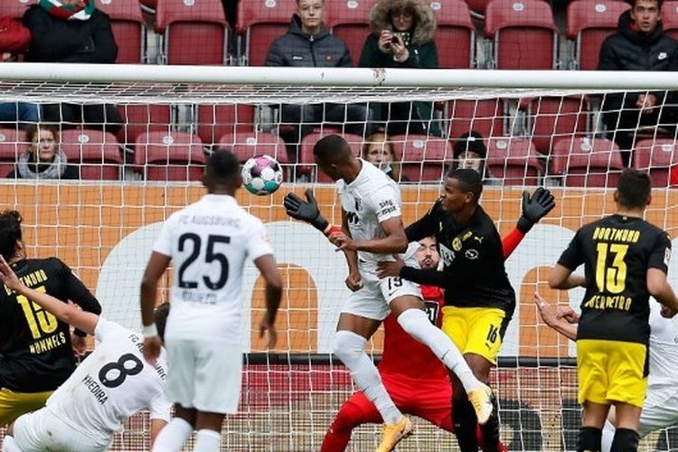 Felix Uduokhai menyundul bola dalam laga Augsburg vs Dortmund pada lanjutan pekan kedua Bundesliga Jerman 2020-2021 yang digelar di Stadion WWK Arena, Sabtu (26/9/2020).