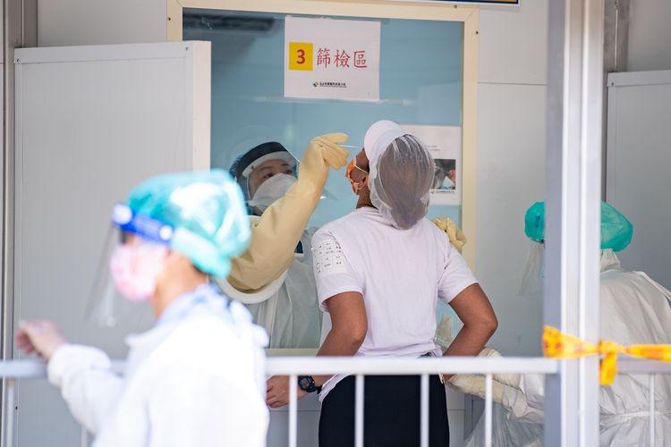 Petugas medis melakukan tes swab Covid-19 kepada seorang warga di posko tes swab kota Taoyuan, Taiwan.