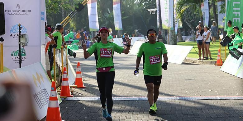 Peserta Herbalife Bali International Triathlon (HBIT) 2015 berlari menuju garis finis di kawasan Pantai Jimbaran, Bali, Minggu (25/10/2015).