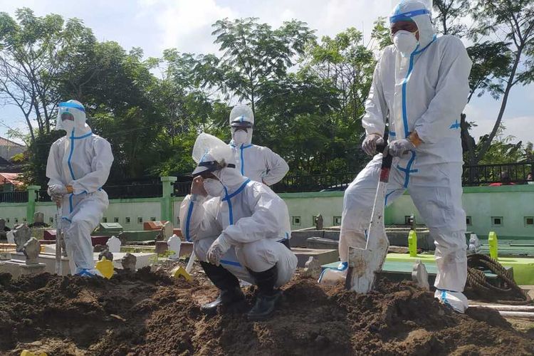 PEMAKAMAN—Fitra bersama timnya sementara memakamkan jenazah pasien covid-19 di Kota Madiun.