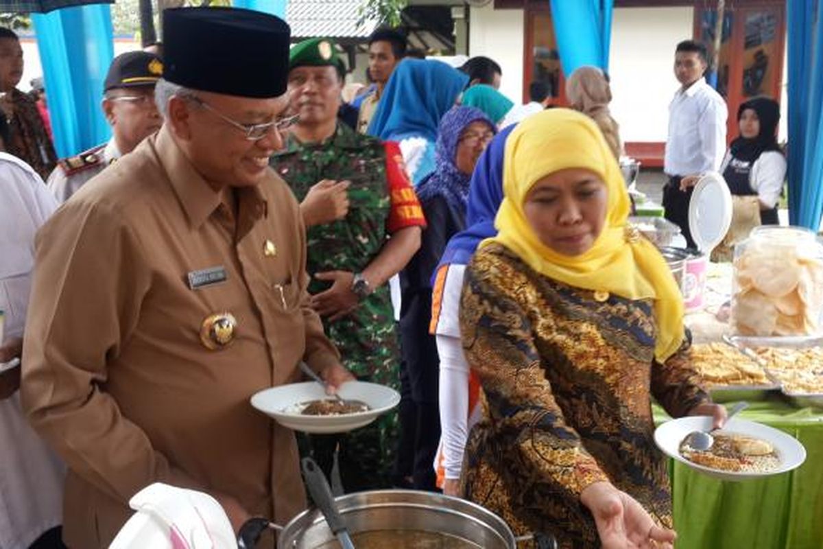 Menteri Sosial RI Khofifah Indar Parawansa (kanan) bersama Bupati Malang Rendra Kresna saat memakan beras sejahtera atau rastra di Perum Bulog Sun Divre Malang, Senin (23/1/2017)