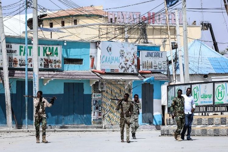 Petugas keamanan berpatroli di dekat lokasi ledakan di Mogadishu pada 20 Agustus 2022. Sedikitnya 13 warga sipil tewas dalam serangan militan Islam di sebuah hotel populer di ibukota Somalia, kata seorang pejabat, saat pasukan keamanan terus memerangi orang-orang bersenjata. dibarikade di dalam. 