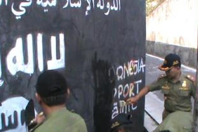 Petugas Satpol PP Sukoharjo hapus gambar dan lambang ISIS di Cemani, Sukoharjo, Selasa (5/8/2014). 