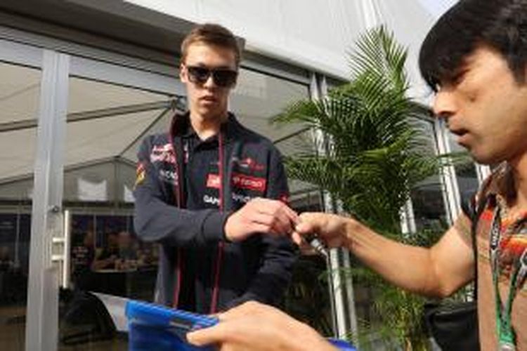 Pebalap Toro Rosso asal Rusia, Daniil Kvyat, memberikan tanda tangan kepada penggemar saat tiba di paddock Sirkuit Suzuka pada GP Jepang, Sabtu (4/10/2014).
